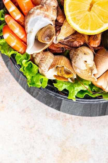 fresh seafood plate snack shrimp crab claw clam rapan trumpeter mollusk meal food on the table