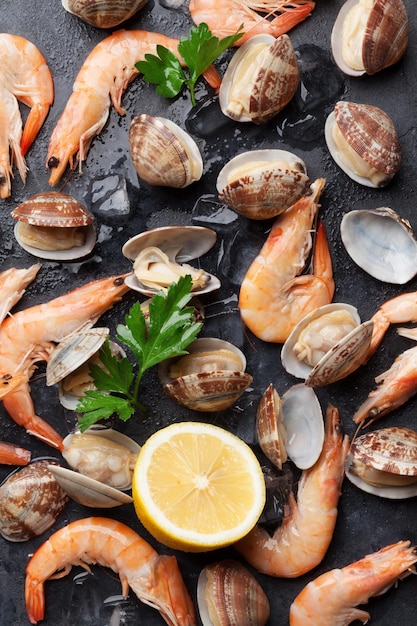 Fresh seafood on stone table Scallops and shrimps