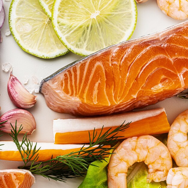 Foto frutti di mare freschi su un tavolo con spezie verdure e olio d'oliva salmone fresco e affumicato gamberetti e bastoncini di granchio per un supermercato o un ristorante di sushi di pesce