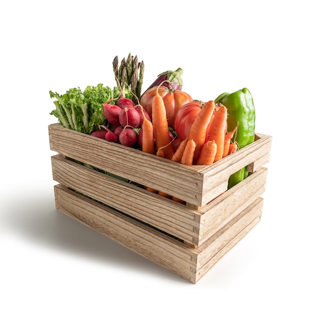 Fresh seasonal vegetables in wooden box, isolated on white background