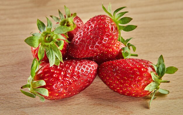 Fresh selected strawberries stacked in slide on wooden background