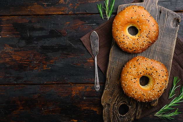 Fresh Sesame Bagel set on old dark wooden table background top view flat lay with copy space for text