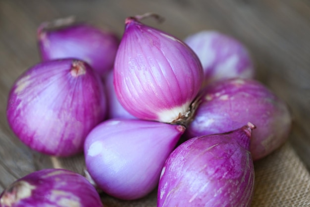 Scalogno fresco per medicinali o erbe e spezie cibo tailandese a base di questo scalogno crudo scalogno o cipolla rossa scalogno viola su fondo di legno