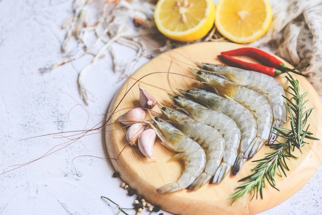 허브와 향신료를 곁들인 신선한 새우 해산물 요리를 위해 준비된 향신료, 나무 접시에 생새우