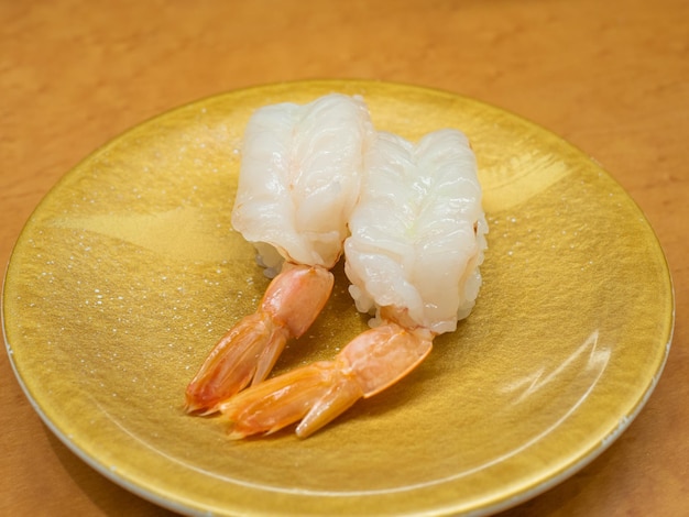 Fresh shrimp sushi on a golden plate ready to eat