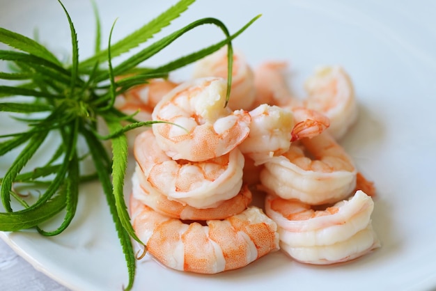 Fresh shrimp on white plate cooked shrimps prawns seafood with herb cannabis leaf cooking boiled shrimp