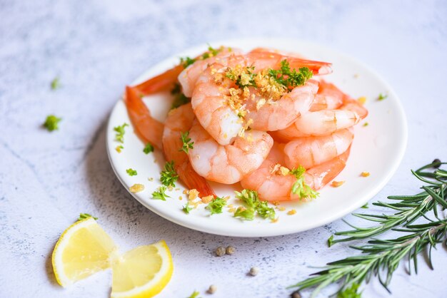 Fresh shrimps served on white plate with herbs and spice