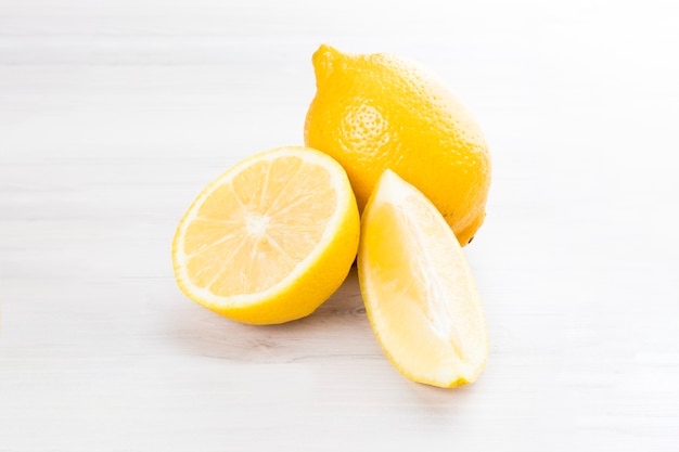 Fresh sicilian lemon slice isolated on a white wooden background.
