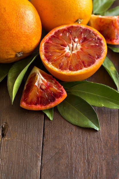 Fresh Sicilian oranges with leaves on a wooden table