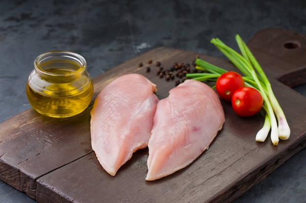 Fresh skinless raw chicken breastfillet arranged on a wooden board