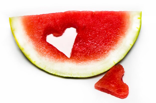 Fresh slice of watermelon with heart isolated on white background.