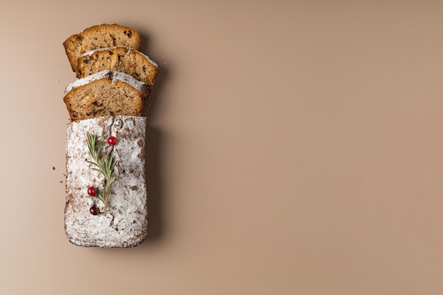 Fresh sliced christmas muffin with dried fruits and nuts on a beige background minimalism