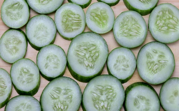 Photo fresh sliced cucumber on wood cutting board