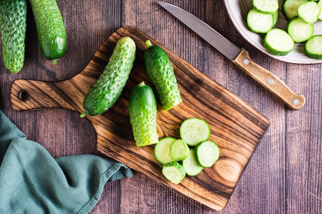 Fresh sliced cucumbers on a cutting board on the table organic\
diet food top view