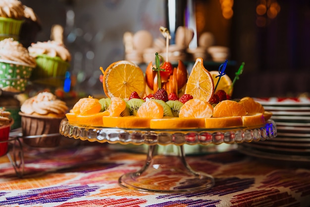 Fresh sliced fruit lies on a stand, ready to serve. Candy bar .