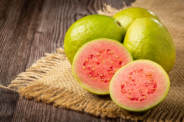 Fresh sliced guavas on wooden table