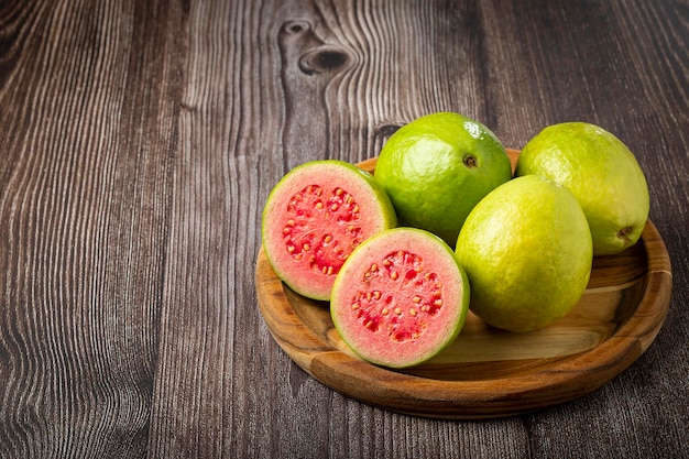 Photo fresh sliced guavas on wooden table