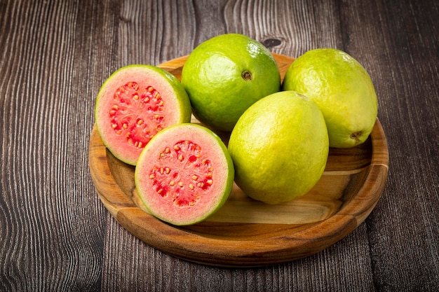 Fresh sliced guavas on wooden table