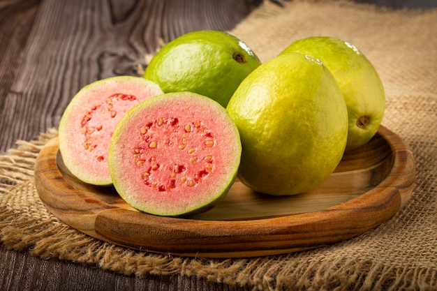 Fresh sliced guavas on wooden table