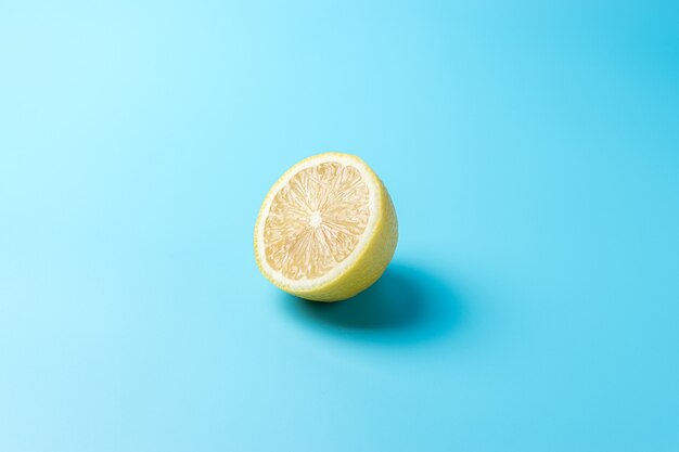 Fresh sliced lemon on blue surface.