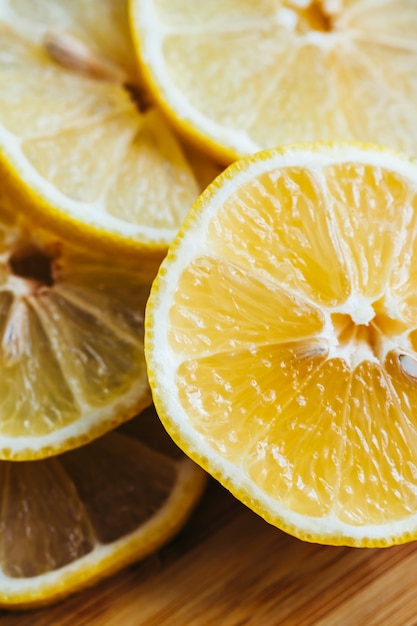 Fresh sliced lemon on the wooden board, close-up.