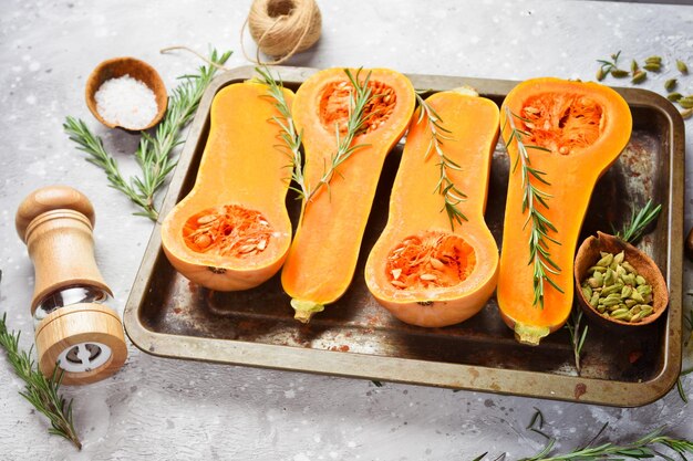 Fresh sliced pumpkin with rosemary and spices The concept of healthy eating in the autumn season On a stone background