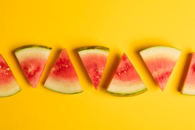 Fresh sliced watermelon on a bright yellow background