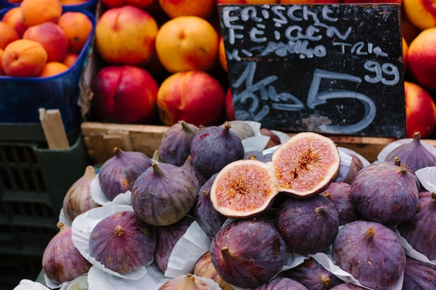 Свежий нарезанный и цельный инжир и нектарин для продажи на фермерском рынке в Вене.