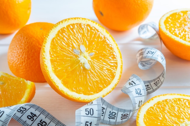 Fresh sliced and whole oranges, and measuring tape.