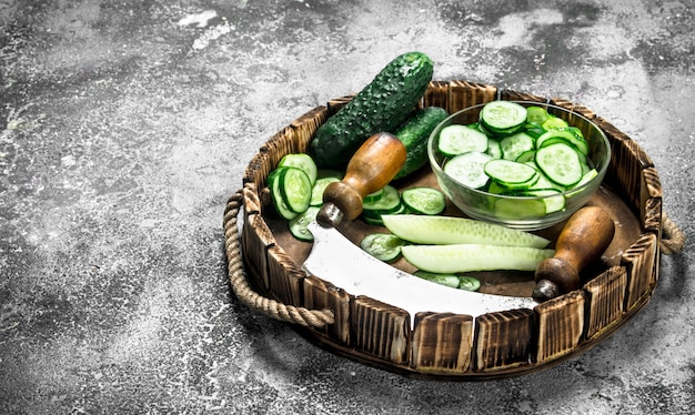 Fresh slices cucumbers on a wooden tray. on a rustic background