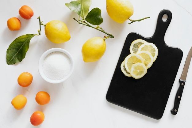 Fresh slices of lemon on a black chopping board flatlay