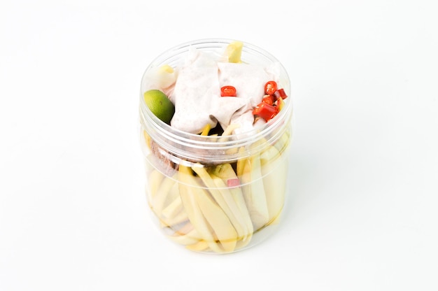 Fresh slices of mango in a plastic jar isolated on a white background