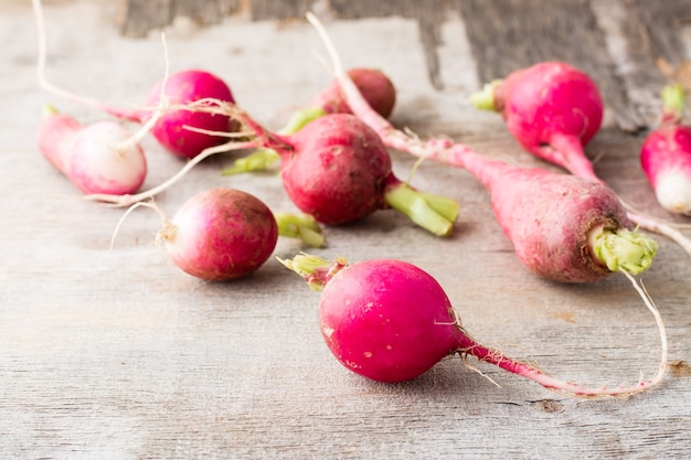 Fresh slightly overgrown radishes on a wooden table. Rustic style