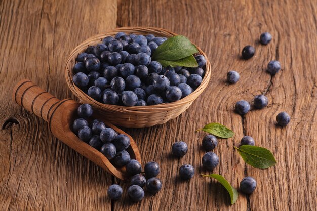 Fresh sloes in bowl on wooden table. Natural remedy