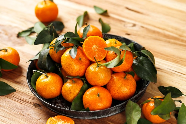 Fresh Small Mandarin Oranges Fruit or Tangerines with Leaves on a Wooden Table