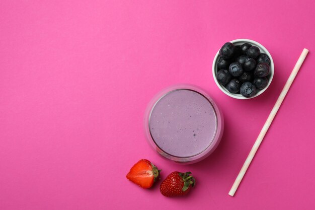 Fresh smoothie, ingredients and straw on pink background