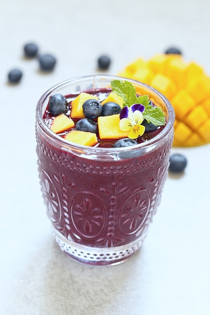 Fresh smoothie with mango and blueberry topping