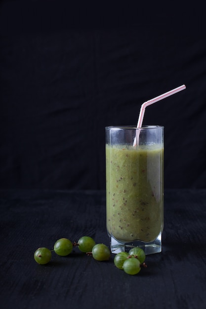 Fresh smoothies from gooseberry in a glass of styot on a black table