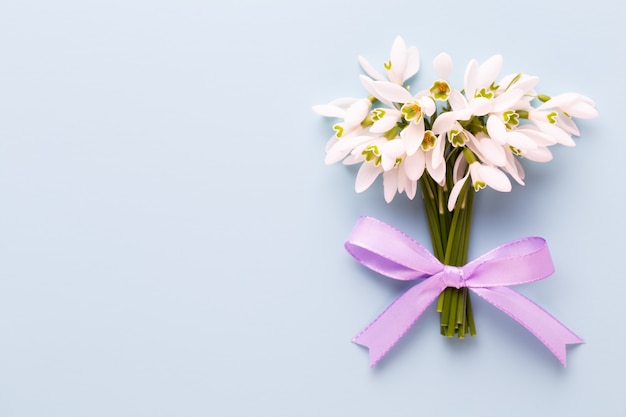 Fresh snowdrops on blue background with place for text.  