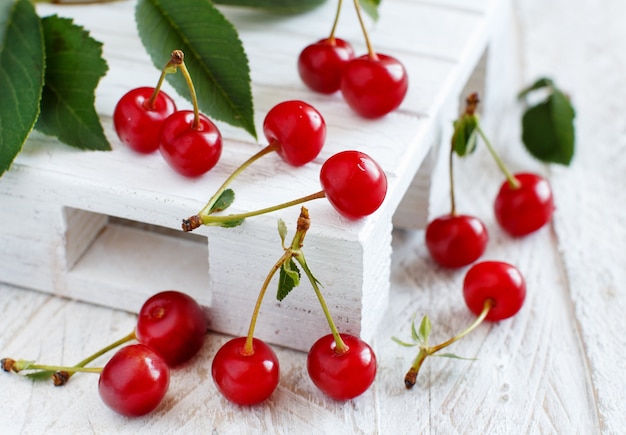 Fresh sour cherries  on a white wooden table