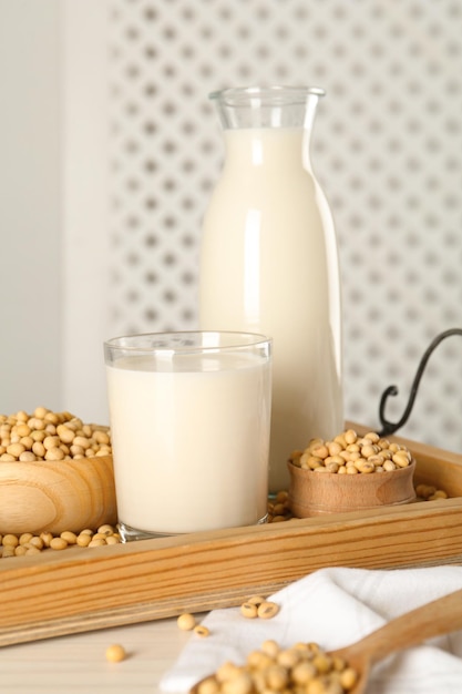 Photo fresh soy milk and beans on wooden table closeup