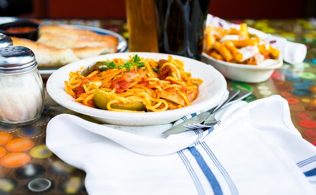 Foto spaghetti freschi con salsiccia peperoni e cipolle nel ristorante italiano.