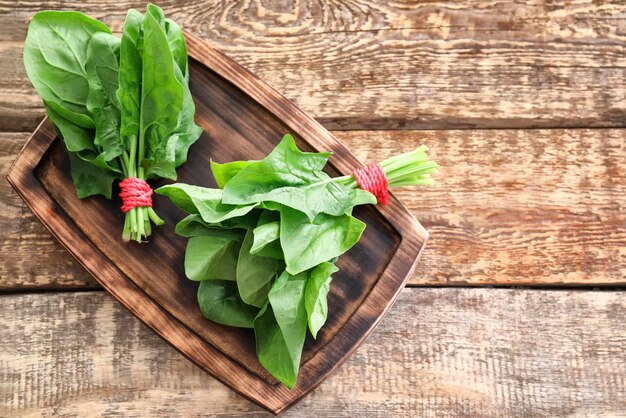 Fresh spinach bunches on wooden board