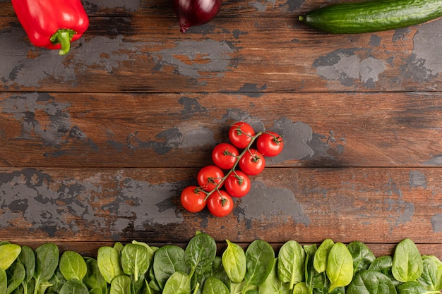 Fresh spinach leaves on a rustic wooden table. Top view.