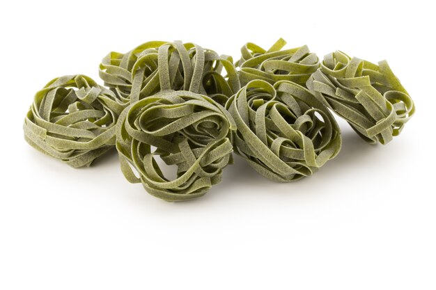 Fresh spinach with green pasta on white background.