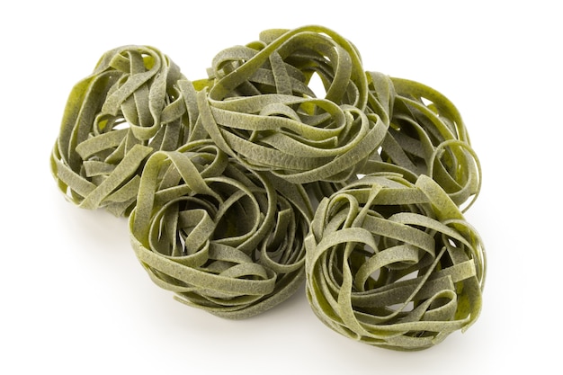 Fresh spinach with green pasta on white background.