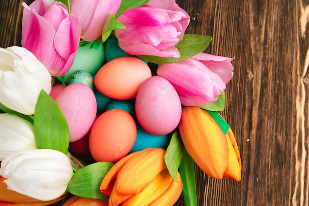 イースターのお祝いのための塗られた卵と新鮮な春の花