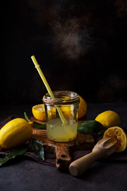 Fresh squeezed juice from lemon halves with a juicer in a glass jar, selective focus