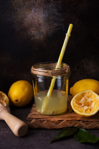 Fresh squeezed juice from lemon halves with a juicer in a glass jar, selective focus