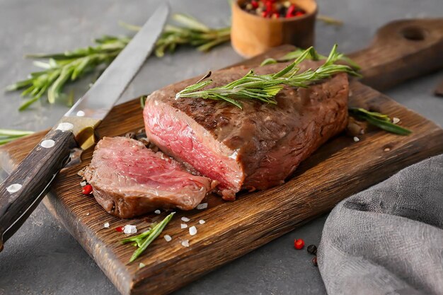 Foto bistecca fresca su una tavola da taglio con un coltello